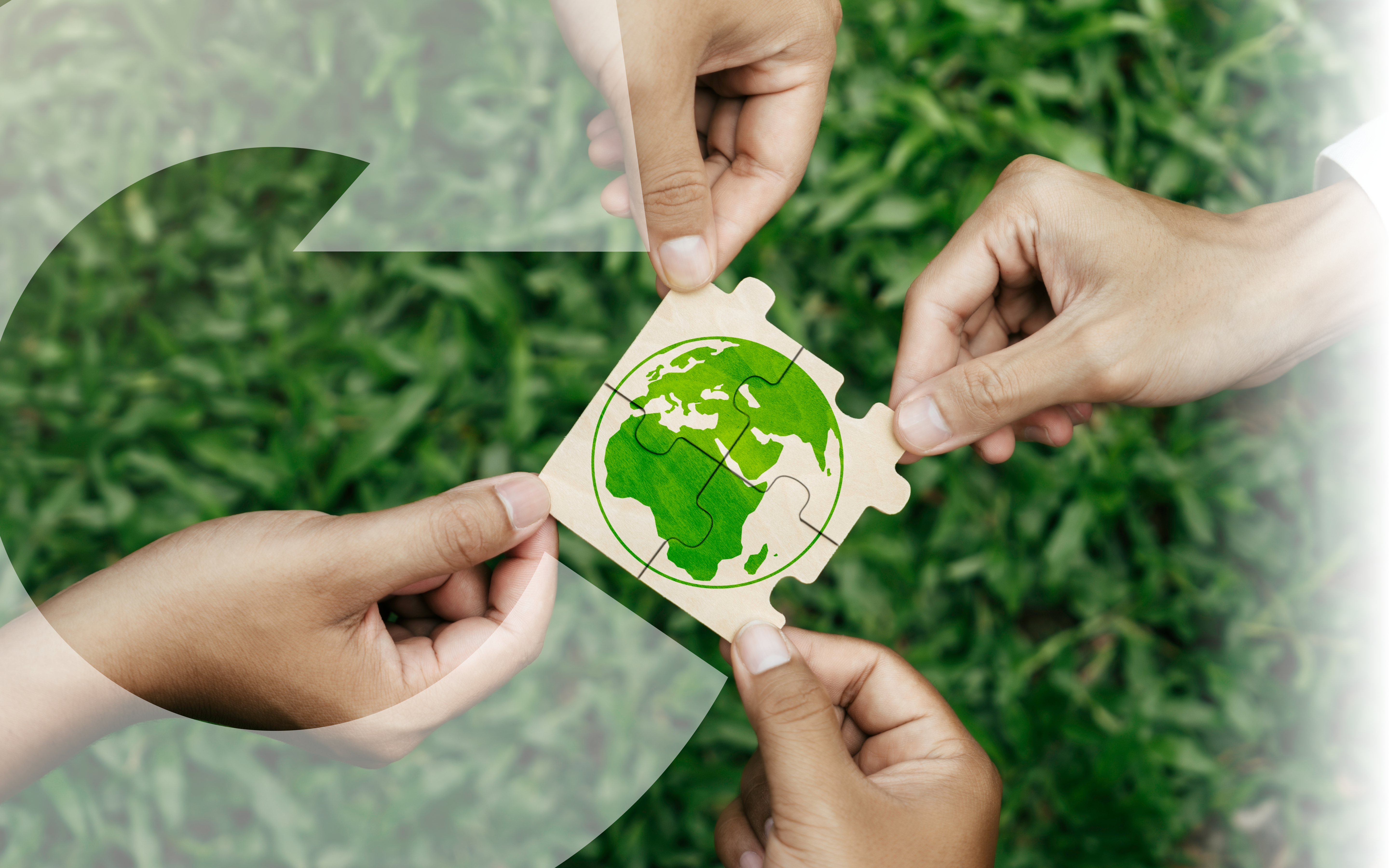 Four connected puzzle pieces with a green image of the world, each help in the corner by a different hand with grass in the background. There is also a watermark circular arrow in the foreground.